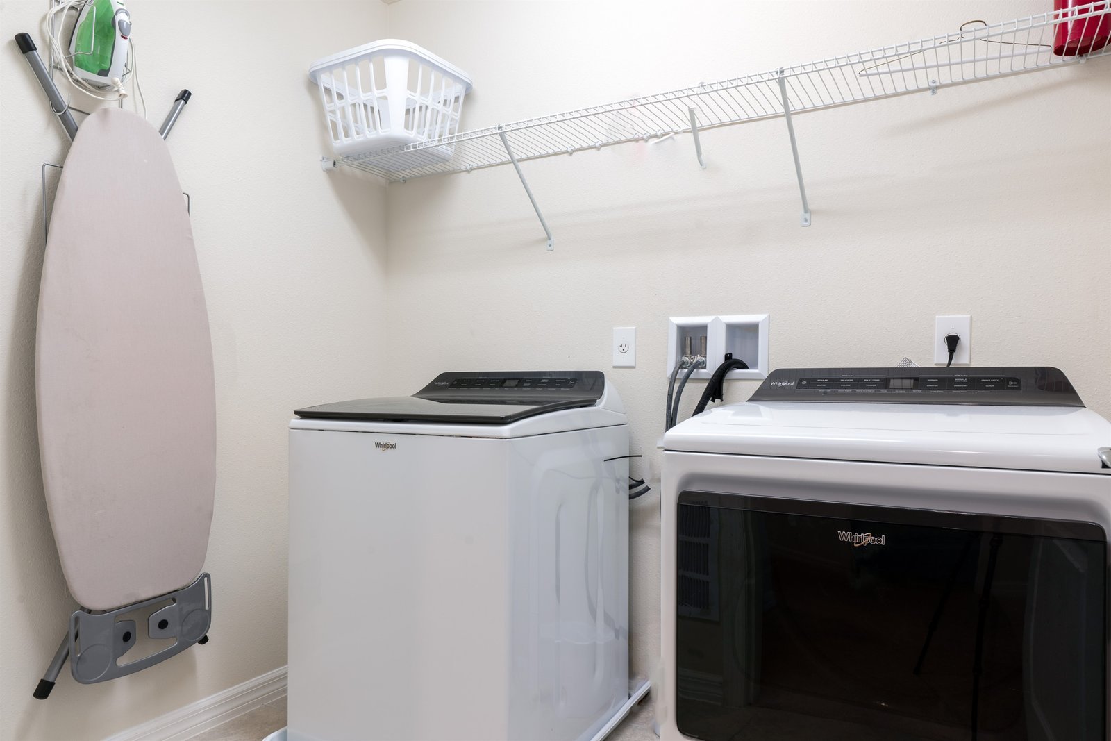 Laundry area with washer, dryer, iron, board, linens, and pool towels